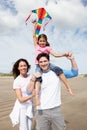 Family Having Fun Flying Kite On Beach Holiday Royalty Free Stock Photo