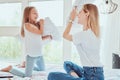 Family having funny pillow fight on bed. Beautiful mom with her little cute daughter spending free time together Royalty Free Stock Photo