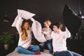 Family having funny pillow fight on bed. Parents spending free time with their son. Young family being playful at home Royalty Free Stock Photo