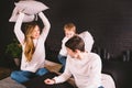 Family having funny pillow fight on bed. Parents spending free time with their son. Young family being playful at home Royalty Free Stock Photo