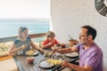 Family having lunch on the balcony with sea view Royalty Free Stock Photo