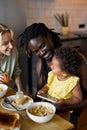 family having meal and using smartphone, parents with child in cozy kitchen Royalty Free Stock Photo