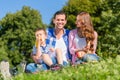 Family having picnic sitting in grass on meadow Royalty Free Stock Photo