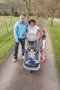 Family Having Ride In Wheelbarrow In Countryside