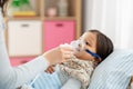 Mother and sick daughter with oxygen mask in bed