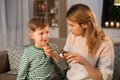 Mother giving medication or cough syrup to ill son