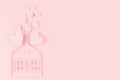 Family hearth - paper house with flying hearts on soft pink color background. Copy space. Valentine day concept for design.