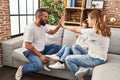 Family high five with hands raised up sitting on sofa at home Royalty Free Stock Photo