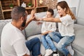 Family high five with hands raised up sitting on sofa at home Royalty Free Stock Photo