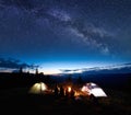 Family hikers having a rest at night camping in mountains Royalty Free Stock Photo