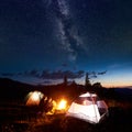Family hikers having a rest at night camping in mountains Royalty Free Stock Photo