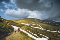 Family hikers walking by the road in a spring mountains Royalty Free Stock Photo