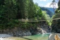 Family hiking across a wooden suspension bridge over the Rhine River in the Viamala Gorge in the Swis Alps Royalty Free Stock Photo
