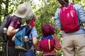 Family hiking with backpacks in forest