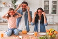 Family holding bell papper rings on the eyes and smiling at the camera