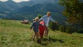 Family holding hands playing active game on meadow. Parents have fun with kids. Royalty Free Stock Photo