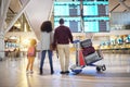 Family, holding hands and travel waiting at airport checking flight times for departure, trip or vacation together. Mom Royalty Free Stock Photo