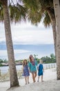 Family walking together on a beach at a tropical beach resort Royalty Free Stock Photo