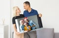 family holding photo canvas with christmas picture Royalty Free Stock Photo