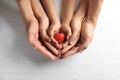 Family holding small red heart in hands Royalty Free Stock Photo