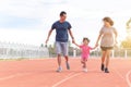 Family holiday Parents take their daughters to walk and run. And playing exercise at the stadium happily and having fun While Royalty Free Stock Photo