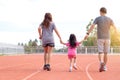 Family holiday Parents take their daughters to walk and run. And playing exercise at the stadium happily and having fun While Royalty Free Stock Photo