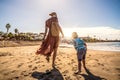 Family holiday on Tenerife, Spain. Mother with son walking on the sandy beach Royalty Free Stock Photo