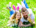 Family holidays concept. Father and daughter on happy faces holds easter eggs, grass on background. Girl with dad lying