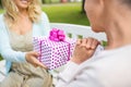 Daughter giving present to senior mother at park Royalty Free Stock Photo