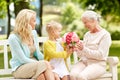 Happy family giving flowers to grandmother at park Royalty Free Stock Photo