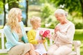 Happy family giving flowers to grandmother at park Royalty Free Stock Photo