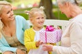 Happy family giving present to grandmother at park Royalty Free Stock Photo