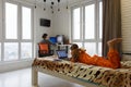 The family is at home, the child lies on the bed and studies in a laptop, the mother in the background works remotely in the Royalty Free Stock Photo