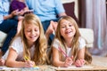 Family at home, the children coloring on floor