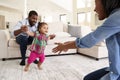 Family At Home Encouraging Baby Daughter To Take First Steps Royalty Free Stock Photo