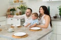 Family in home kitchen - married couple with small child and pregnant woman Royalty Free Stock Photo