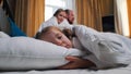 A family in the hotel room - a little girl sleeping in bed - smiling mom and dad looking at her Royalty Free Stock Photo