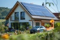 Family house with solar panels on the roof and electric car charging next to it. Royalty Free Stock Photo