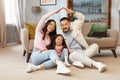 Happy Japanese Parents Joining Hands Making Roof Above Daughter Indoor Royalty Free Stock Photo