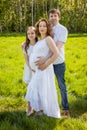 Family husband pregnant wife and daughter expecting baby green park outside