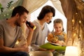 Happy family reading book in kids tent at home Royalty Free Stock Photo