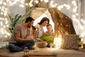 Happy family reading book in kids tent at home Royalty Free Stock Photo