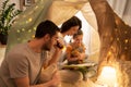 Happy family reading book in kids tent at home Royalty Free Stock Photo