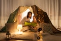 Happy family reading book in kids tent at home Royalty Free Stock Photo