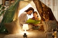 Happy family reading book in kids tent at home Royalty Free Stock Photo