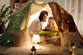 Happy family reading book in kids tent at home Royalty Free Stock Photo