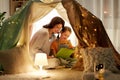 Happy family reading book in kids tent at home Royalty Free Stock Photo