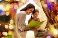 Happy family reading book in kids tent at home Royalty Free Stock Photo