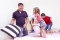 Family Ideas. Happy Caucasian Family of Four Having a Playful Funny Pillow Fight on Bed Indoors with Positive Emotions Royalty Free Stock Photo