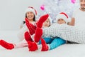 Family idyll, young parents and children in christmas morning sitting close to xmas tree at home in living room Royalty Free Stock Photo